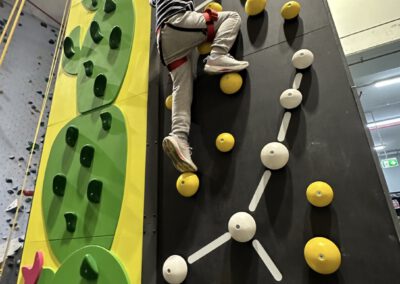 Kids at an indoor climbing wall.