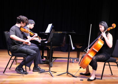 Kids playing music together on a stage.