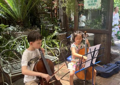 Two kids playing instruments outside.
